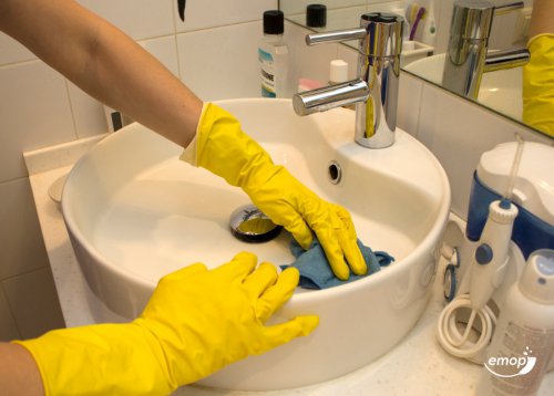 cleaner cleaning the washbasin